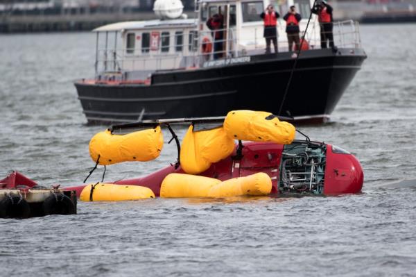 The helicopter on its side in the water
